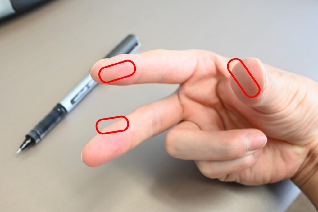 親指と人差し指の腹の部分，中指の第一関節の人差し指側の3か所でペンを持ちます。